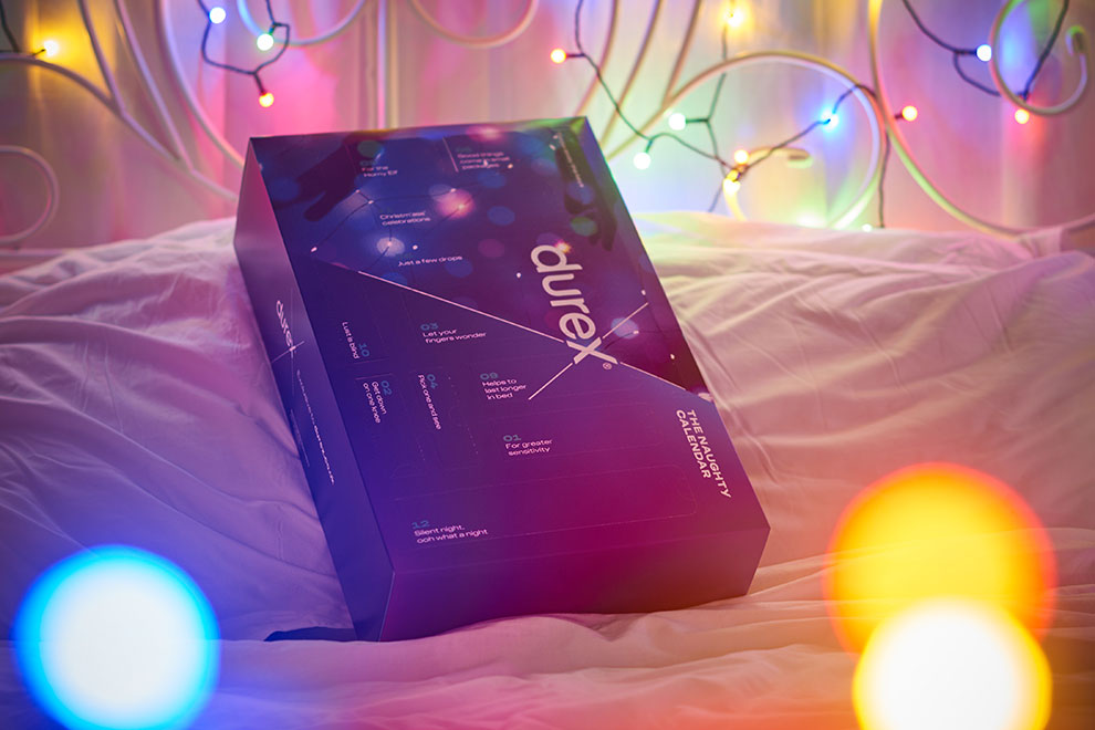 Durex advent calendar gift box placed on a bed with fairy lights