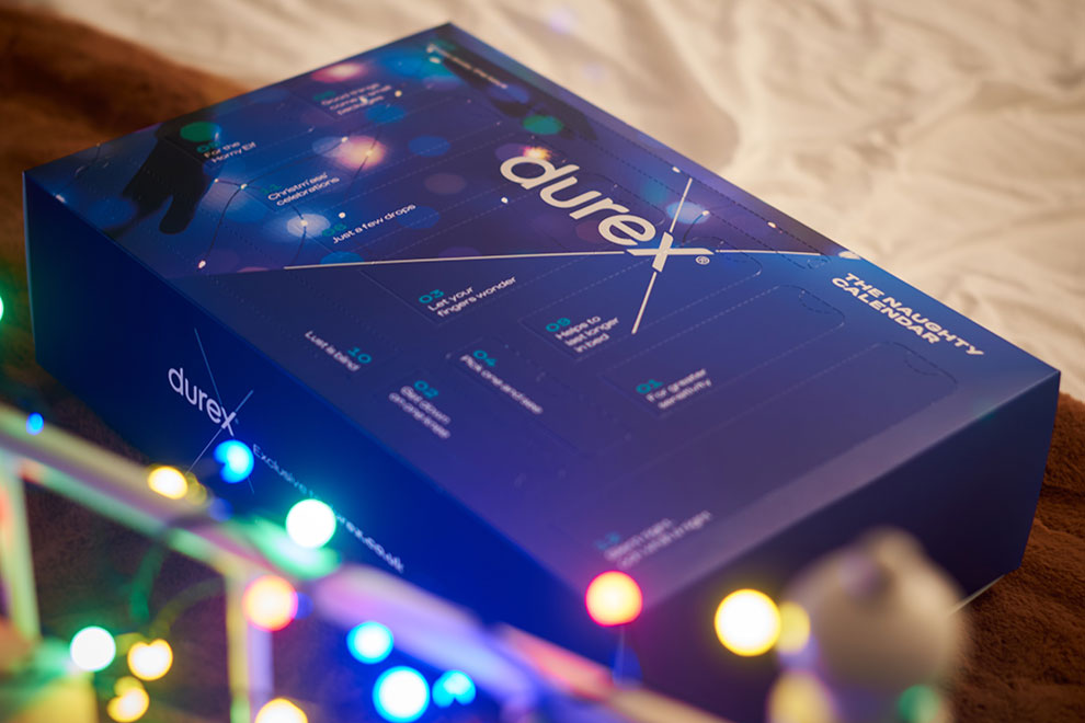 Durex advent calendar gift box placed on a bed with fairy lights