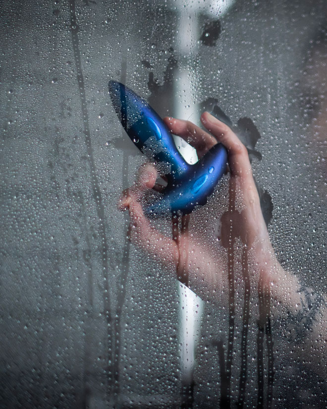 A Durex toy pressed against the inside of a wet shower screen