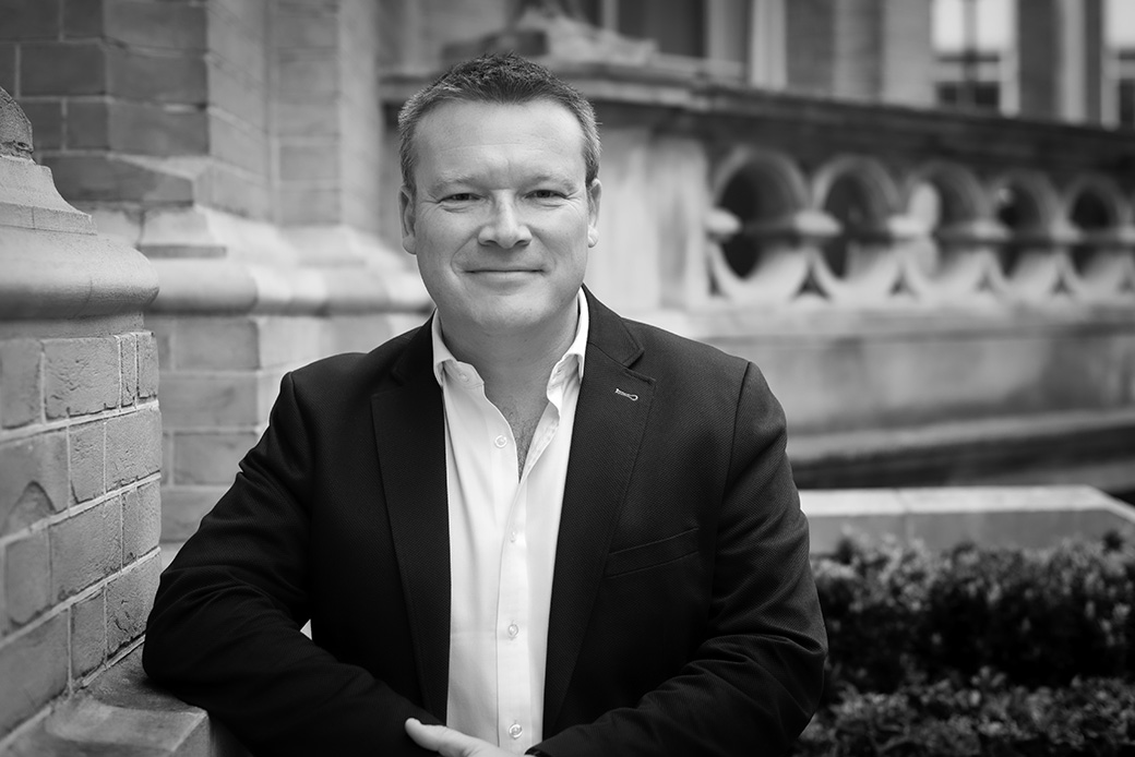 Professional man posing confidently in city environment, monochrome corporate image
