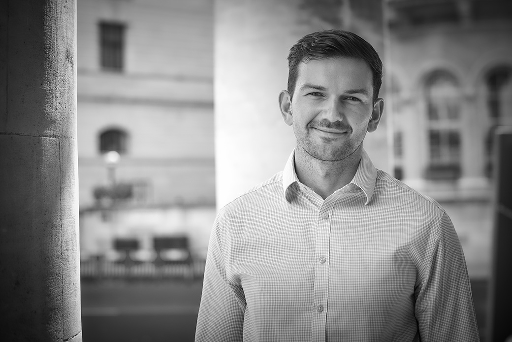 Professional man posing confidently in city environment, monochrome corporate image
