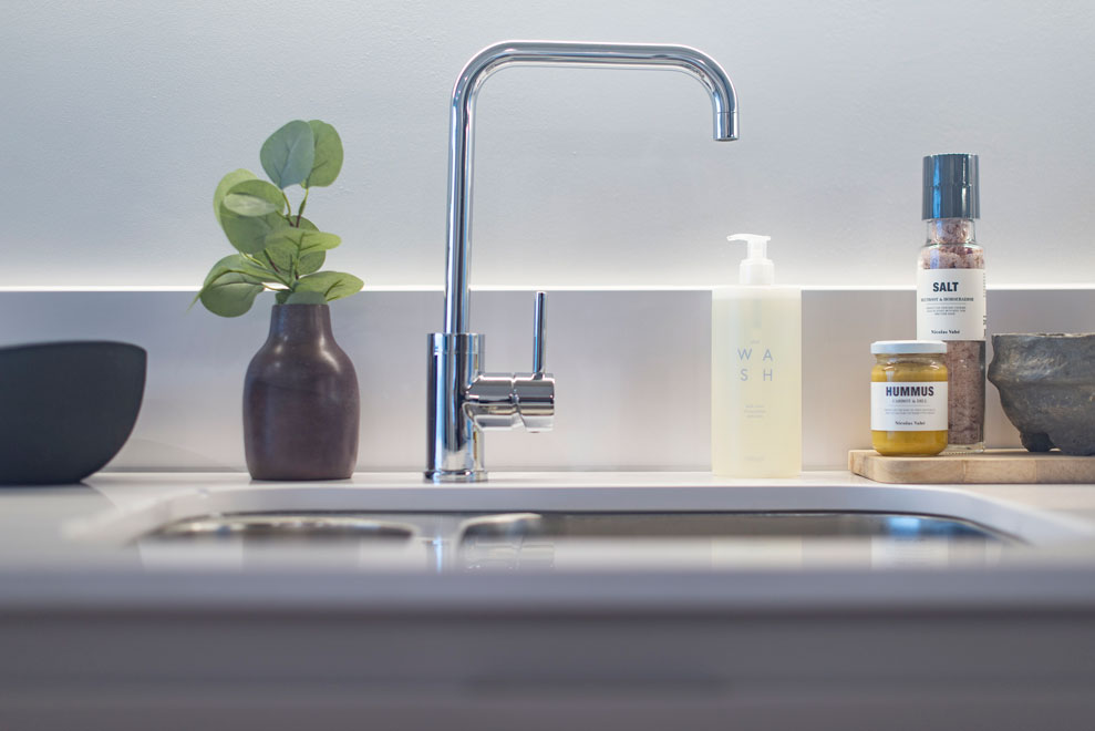 Close up of a stylish curved tap in a contemporary kitchen.