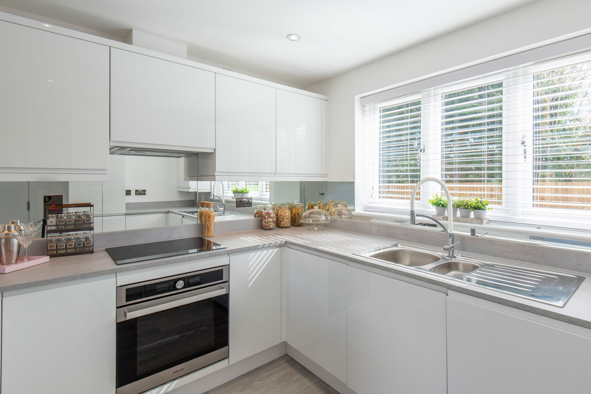 Sleek, white, contemporary kitchen with fitted units and appliances