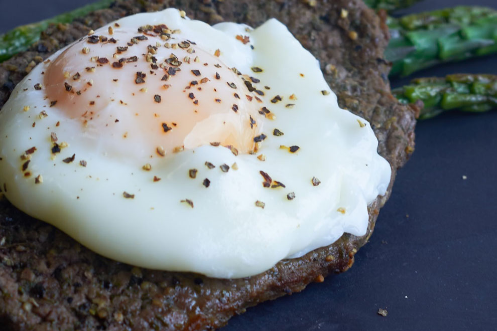 Poached egg served on a savoury patty with asparagus, captured in a high-end food photoshoot