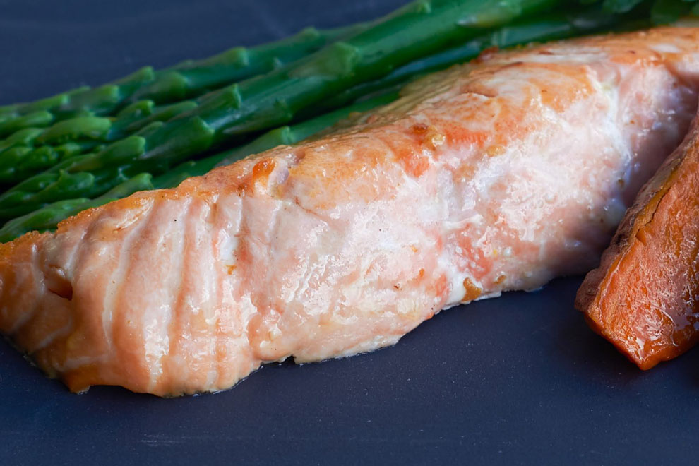 Grilled salmon fillet with roasted carrot and asparagus, ideal for health-conscious food photography